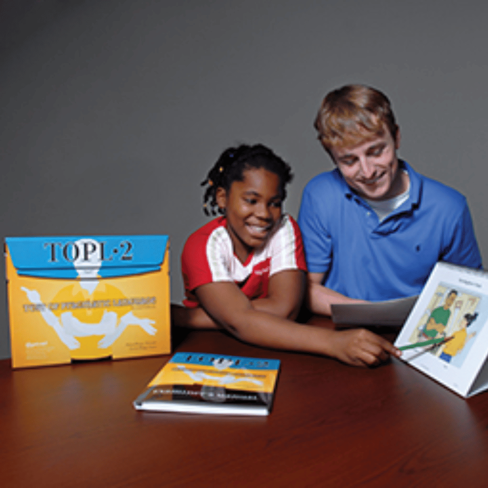 Man and young girl looking at a book together with educational materials on a table.