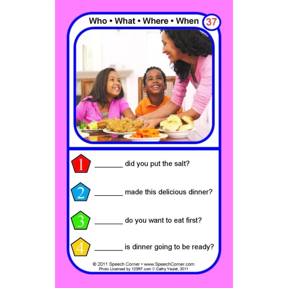 A children's educational card titled 'Who • What • Where • When 37' with a photo of a woman and two children at a dinner table, plus four fill-in question lines with colored numbered markers on a pink background.