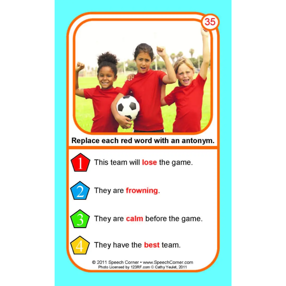 A printed educational card with a bright cyan border, an orange inner frame, and a photo of three children in red shirts holding a soccer ball. Below the photo is the instruction: 'Replace each red word with an antonym.
