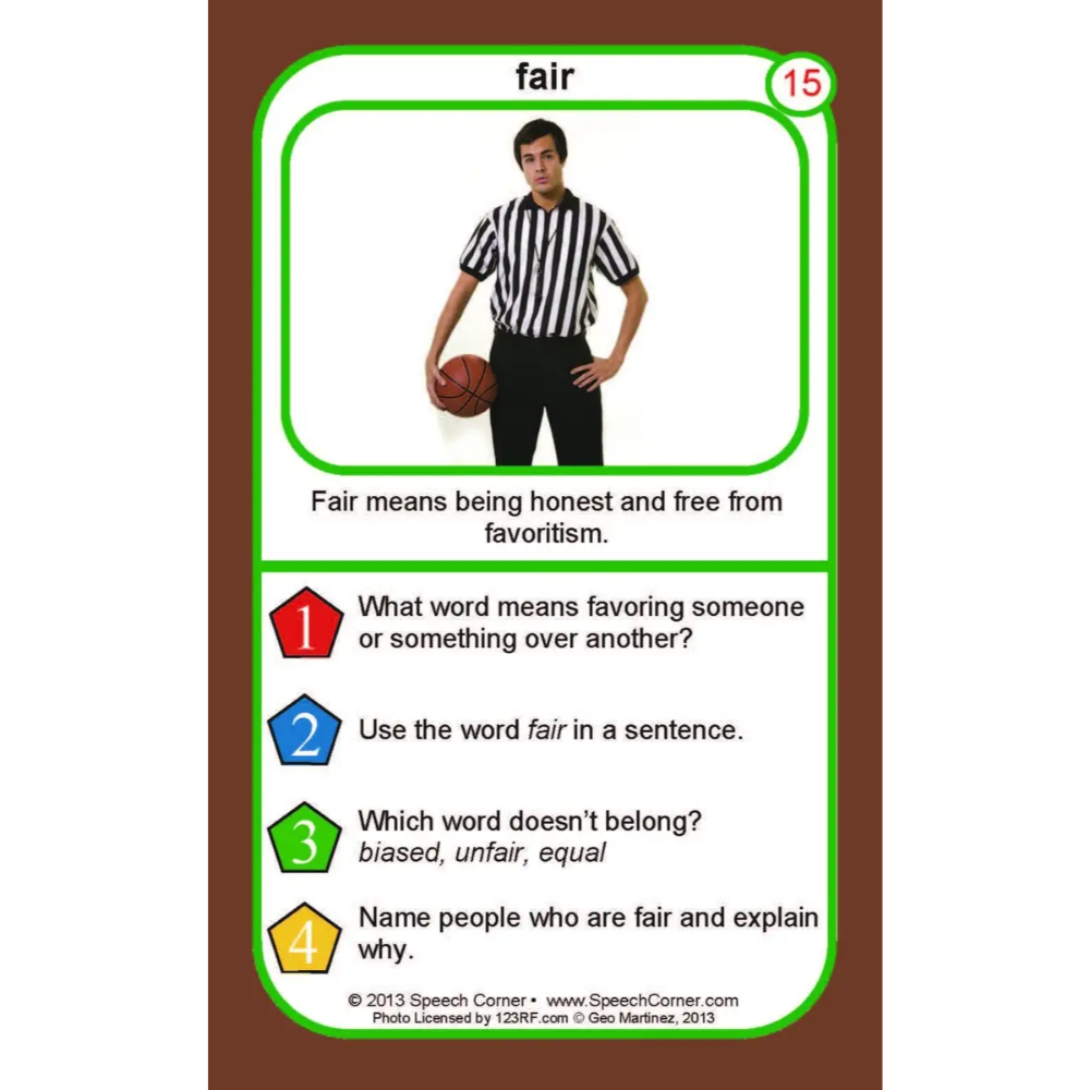 A printed educational card titled "fair" with a photo of a referee holding a basketball and text about the meaning of the word fair, shown on a brown background.