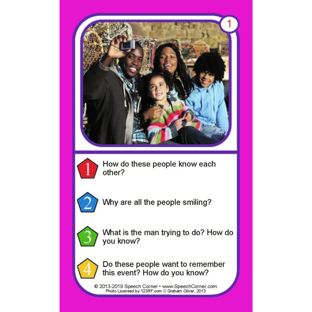 A printed card or worksheet with a bright pink border and a central photo of a family taking a selfie. Below the photo are four numbered questions about the people in the photo, with colored number icons and short text prompts.