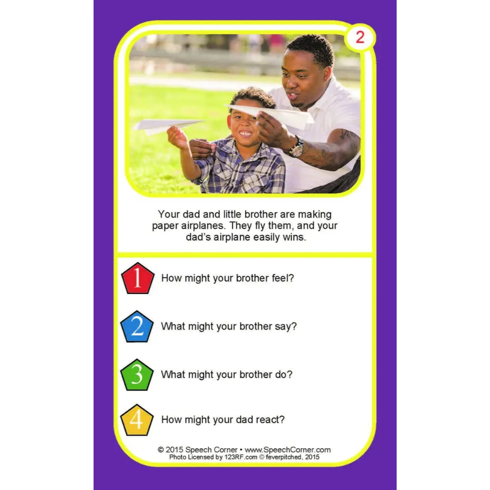 A printed game or activity card with a purple border, a yellow inner border, and a photo of a man helping a child with a paper airplane. The card includes text and numbered question prompts.