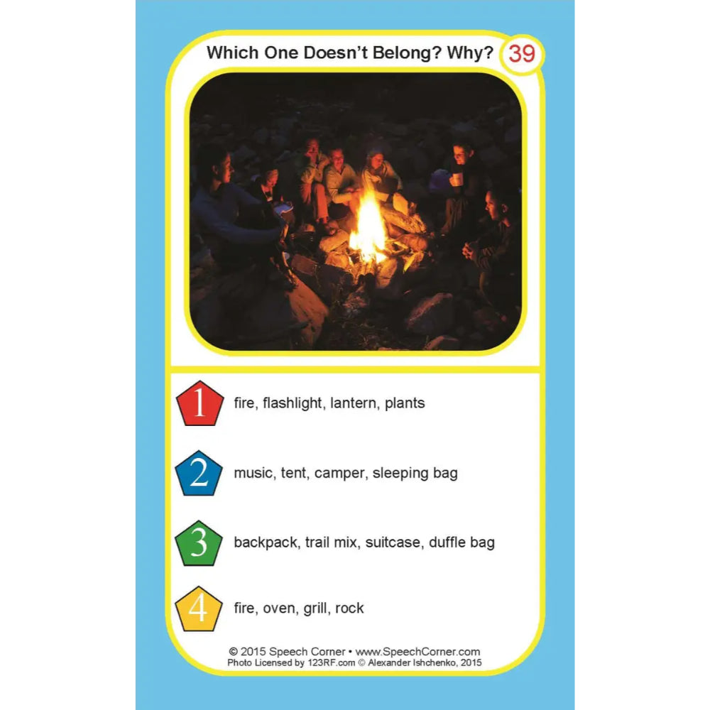 A printed card or worksheet titled "Which One Doesn't Belong? Why?" with the number 39 at the top right. The card has a light blue border, a yellow inner border, a small campfire photo near the top, and four numbered list options with colored labels: fire, flashlight, lantern, plants; music, tent, camper, sleeping bag; backpack, trail mix, suitcase, duffle bag; fire, oven, grill, rock.