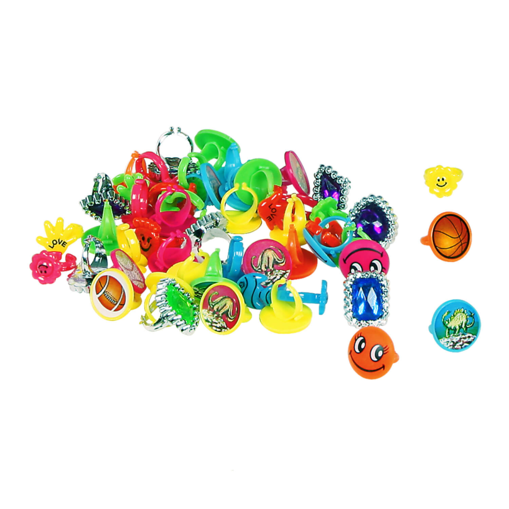 Assorted colorful novelty items including rings and small toys on a white background