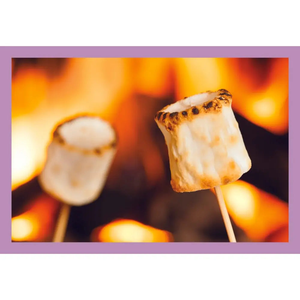 A square print or card featuring a close-up photo of two toasted marshmallows on wooden sticks, with one marshmallow in sharp focus in front of a warm orange fire. The print is framed by a solid lavender border.