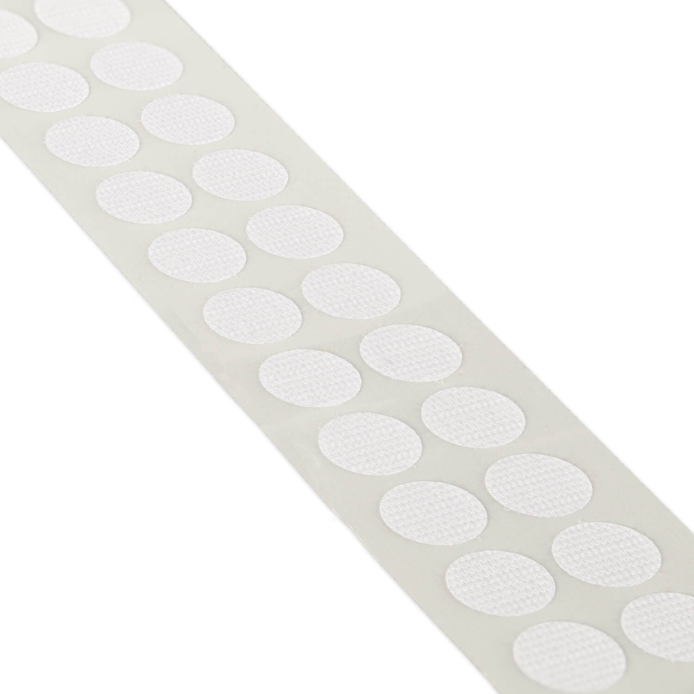 A strip of white oval adhesive velcro patches on a clean white background.